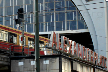 S-Bahnhof am Alexanderplatz in Berlin, die Bahn fährt durch den Torbogen der Halle ein.