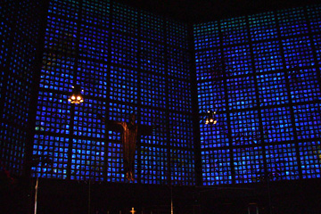 Gedächtniskirche in Berlin, Christus am Hauptaltar. Im Hintergrund das blau leuchtende Fenstermosaik.