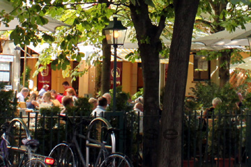 Restaurant mit Bewirtung im Garten mit Halbschatten unter den Lindenbäumen der Gerichtslaube im Nikolaiviertel in Berlin, einem beliebten Ausflugsziel in der Nähe vom Berliner Dom.