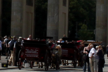 Zwei Pferdedroschken warten auf dem Pariser Platz vor dem Brandenburger Tor auch Fahrgäste für das Sightseeing durch Berlin.