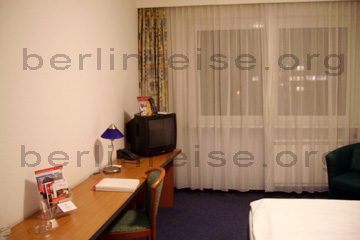 Hotelzimmer im Hotel Ramada in Berlin, Ansicht TV, Schreibtisch, Minibar