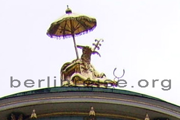 Chinesenfigur auf dem Dach vom Chinesischen Haus in Sanssouci. In der einen Hand hält er einen aufgespannten Schirm und in der anderen eine Stimmgabel. Vom Gesicht des Chinesen erkennt man leider nicht sehr viel.