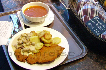 Kalbsschnitzel mit Bratkartoffeln und Pilz-sause und einer Suppe als Vorspeise im KaDeWe am Kurfürstendamm in Berlin.